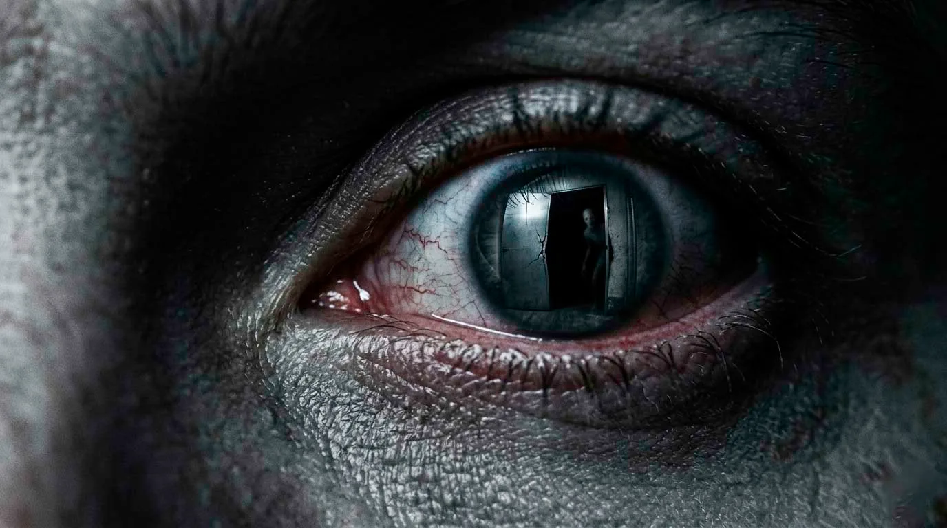 Hombre mirando bajo la cama en la oscuridad mientras una presencia lo observa desde abajo